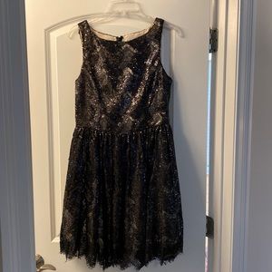 Sequined, knee length black dress.